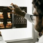 personne en chemise grise à manches longues tenant une tablette noire