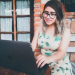 woman in green and white floral tank top wearing black framed eyeglasses