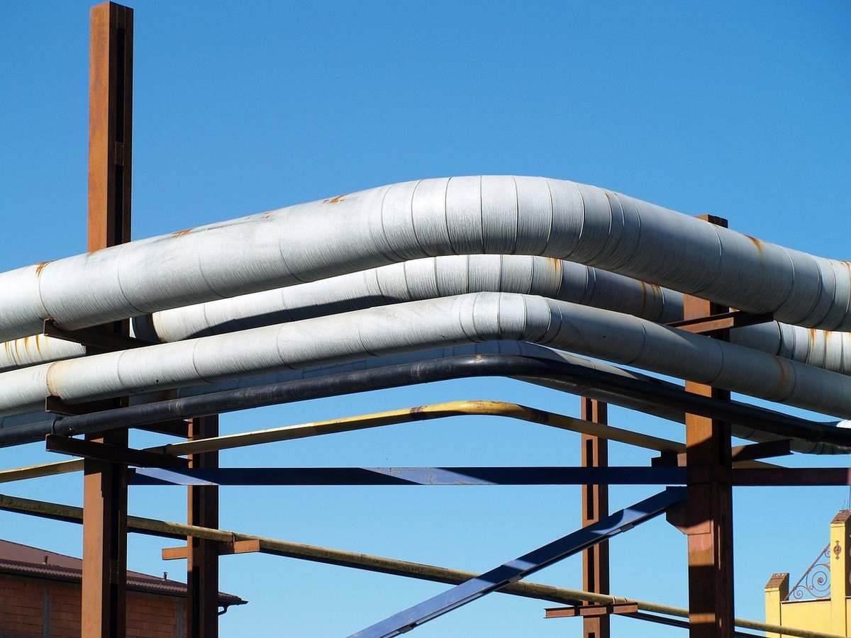 Des tuyaux blancs sur une structure métallique sous un ciel bleu