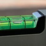 Un niveau à bulle vert avec liquide et bulle centrale sur support