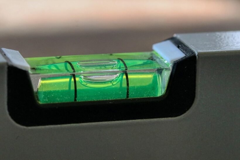 Un niveau à bulle vert avec liquide et bulle centrale sur support