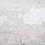 Peinture blanche qui s'écaille sur un mur texturé