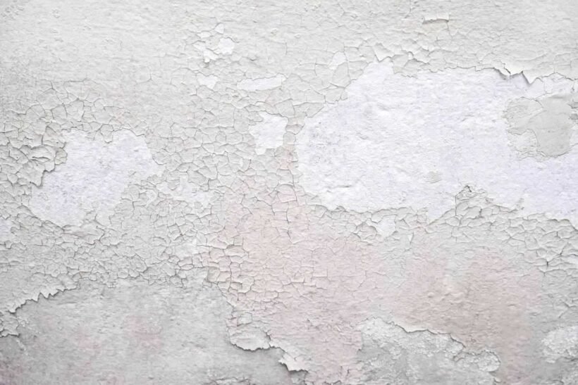 Peinture blanche qui s'écaille sur un mur texturé