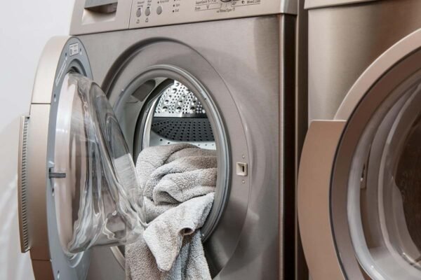 machine à laver ouverte avec torchon dans la porte, salle de lavage